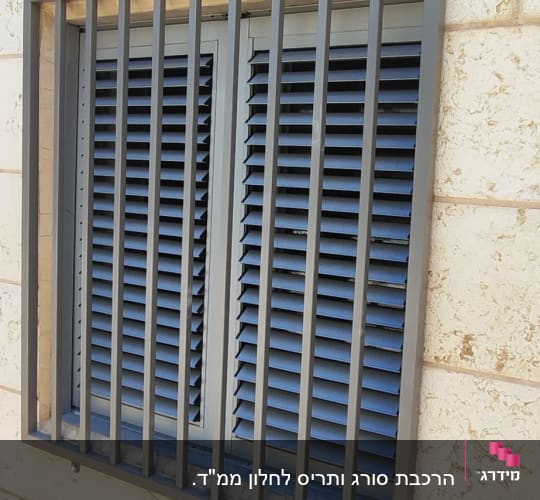 חלון עם תריסים וסורגים על קיר אבן
